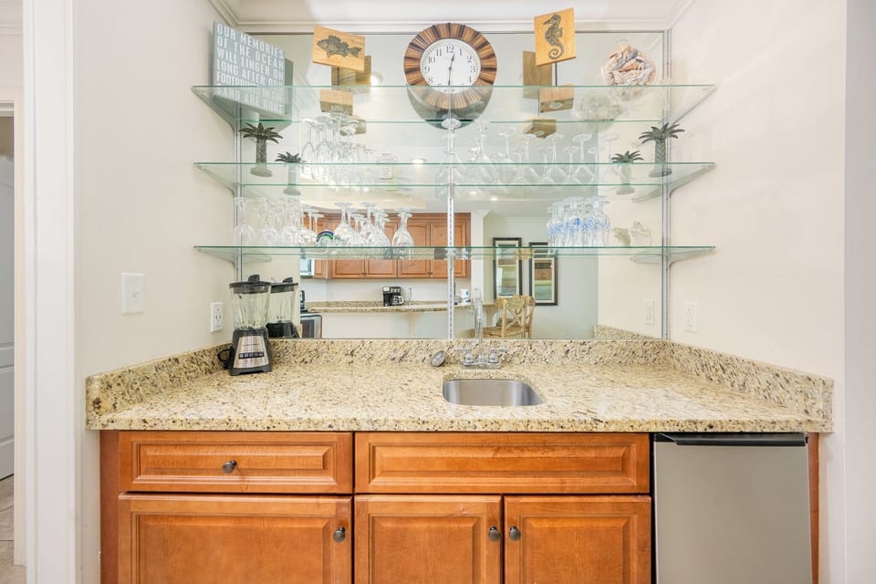 Enjoy crafting refreshing drinks at the wet bar, surrounded by elegant decor and shimmering glassware