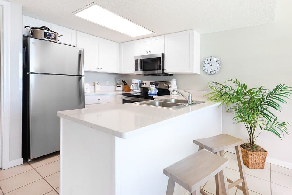 Cook and gather in this functional kitchen featuring sleek appliances, a spacious countertop, and casual seating