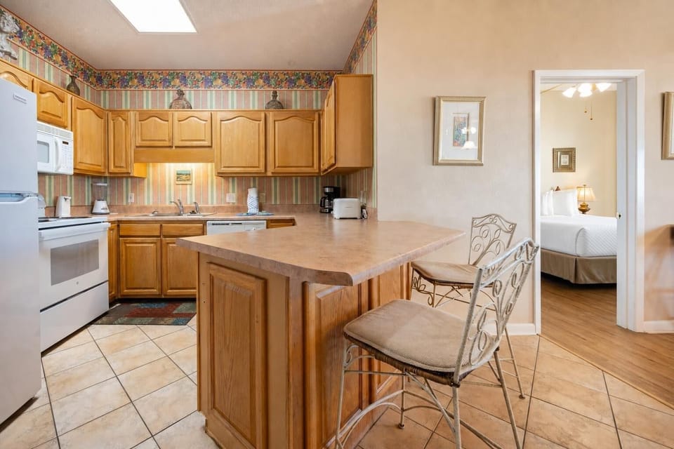 Wooden cabinetry complements the inviting breakfast bar, creating a welcoming space for casual meals and gatherings