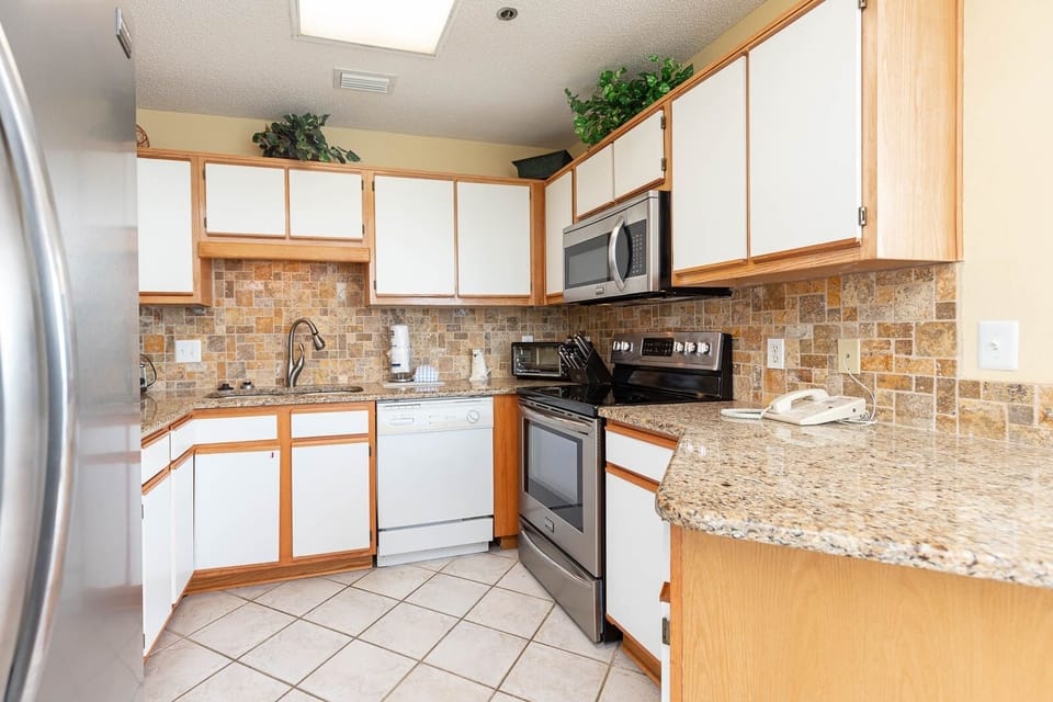 Cook meals in the kitchen featuring stylish granite counters and stainless appliances for a delightful culinary experience