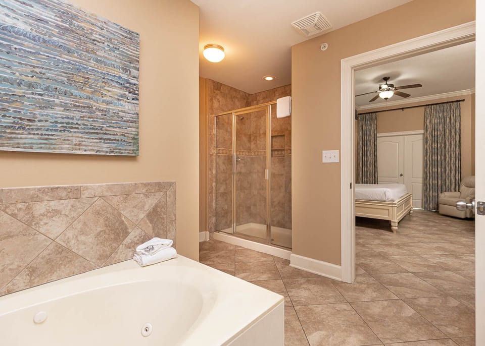 The master bath features a relaxing jetted tub, walk-in shower, and serene palette, perfect for unwinding after a beach day