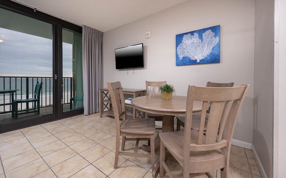Have a family meal or game night around the dining table in the living space with a beachfront balcony view