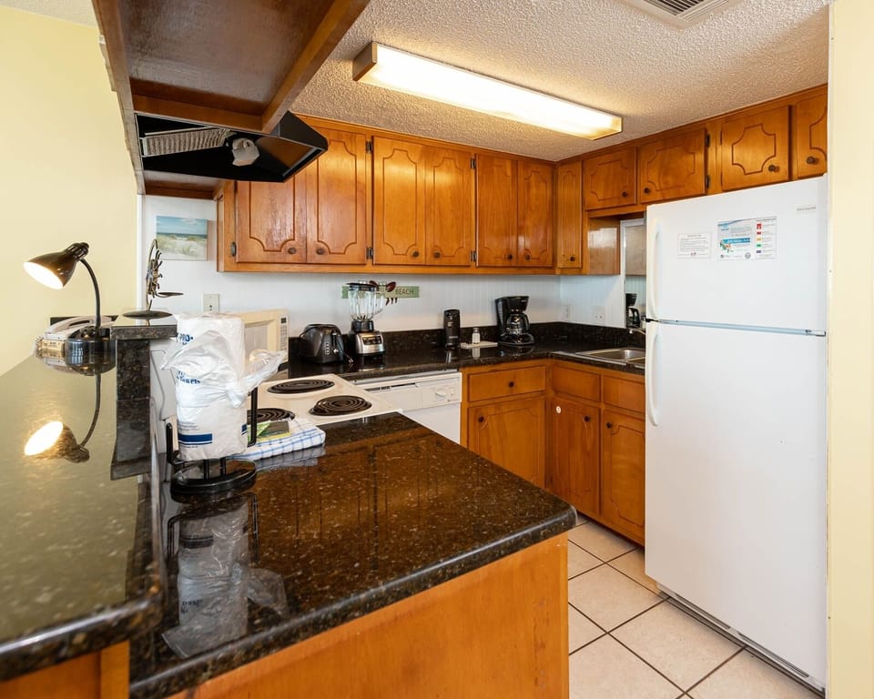 The kitchen features wooden cabinetry, sleek countertops, and essential appliances for a delightful cooking experience