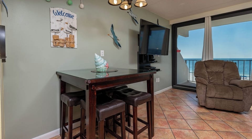 This inviting space features a cozy seating area with a view of the beachfront, perfect for relaxation and enjoyment