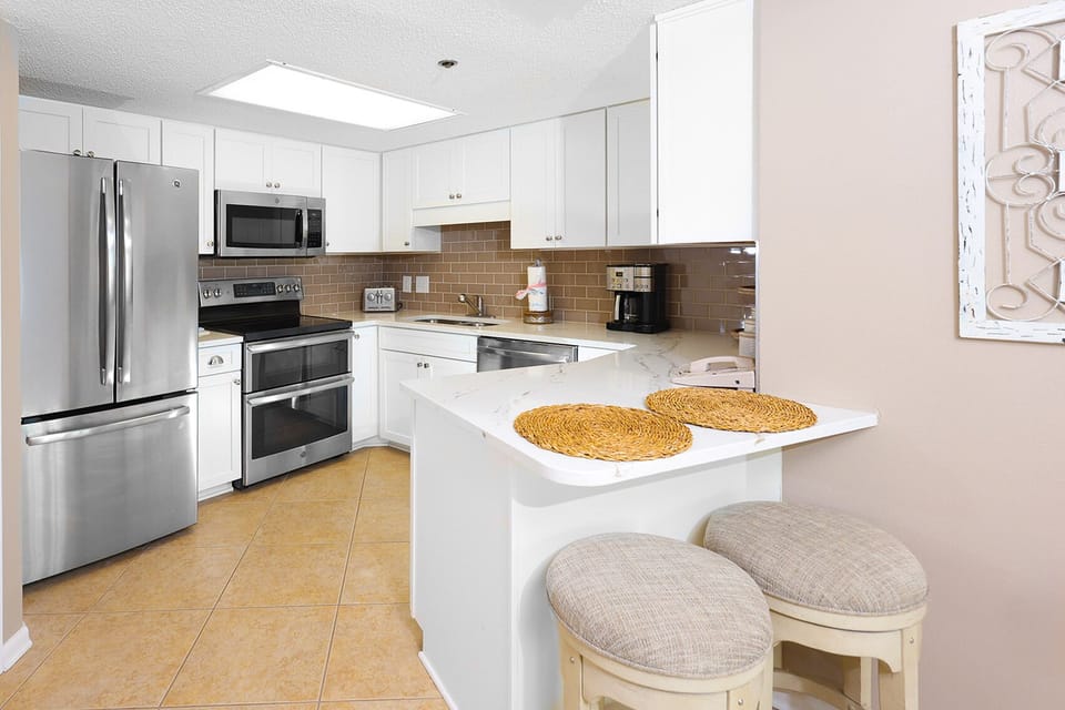 Cook and gather in this inviting kitchen with stainless appliances, a spacious layout, and cozy bar seating