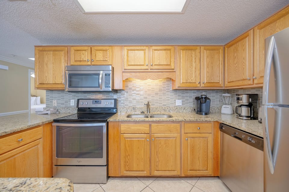 Prepare meals in the spacious kitchen featuring granite countertops, stainless appliances, and a breakfast bar