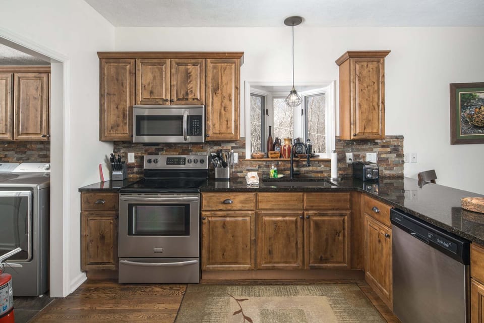 Fully Equipped Kitchen with Rustic Wood Cabinetry and Modern Appliances