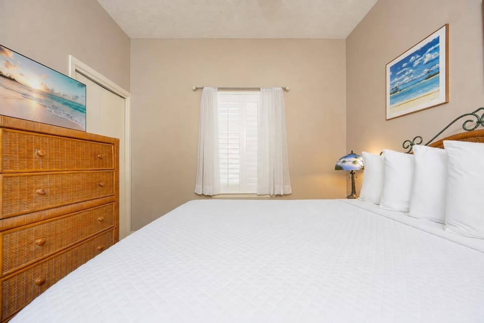 Rest in this comfortable guest bedroom featuring a queen bed, dresser, and natural light from the window
