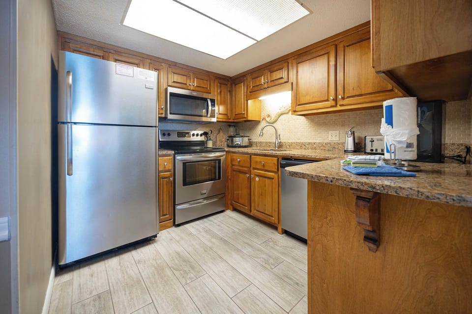 This kitchen features stainless appliances, granite countertops, and a cozy atmosphere perfect for preparing meals