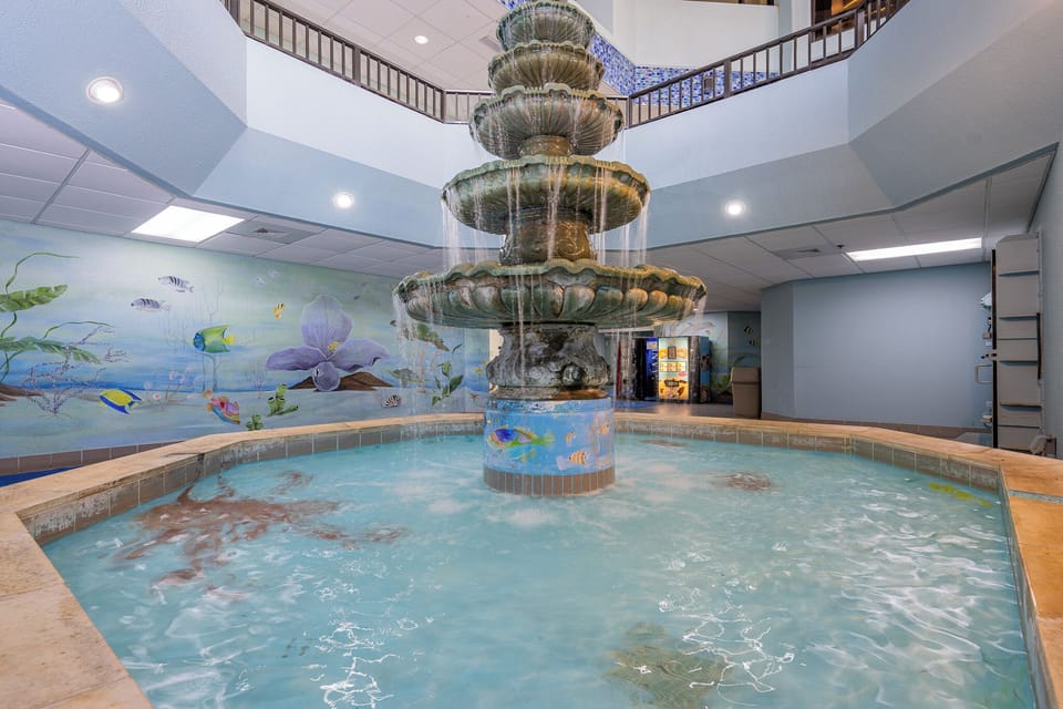 Discover this beautiful indoor fountain surrounded by vibrant murals on your next getaway to Phoenix V in Orange Beach