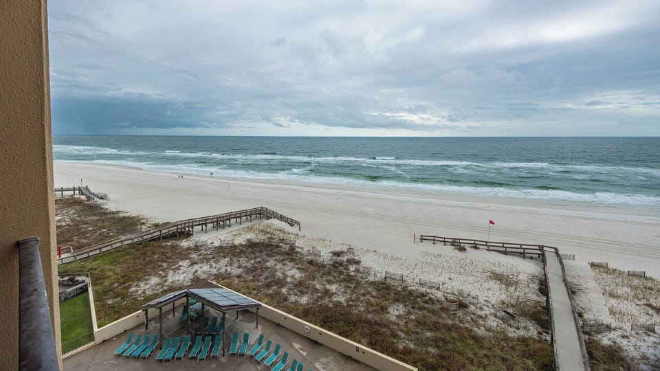 Relax with breathtaking views from the balcony overlooking the sandy beach and tranquil waves, perfect for your retreat