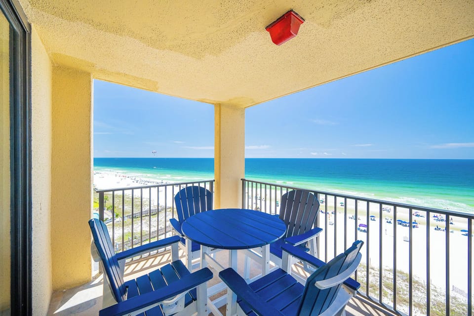Relaxing view from the balcony overlooking the pristine beach and turquoise waters, with seating