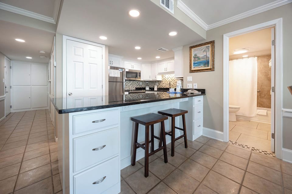 This kitchen features sleek granite countertops, stainless appliances, and a cozy breakfast bar, perfect for casual dining
