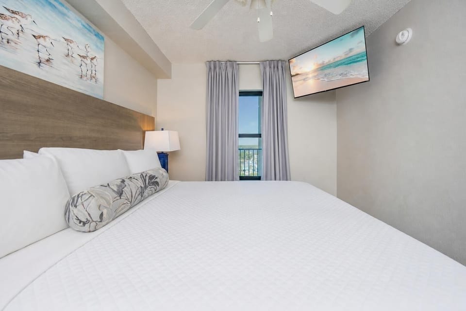 Relax in this comfortable bedroom featuring a king bed and a mounted TV for your entertainment