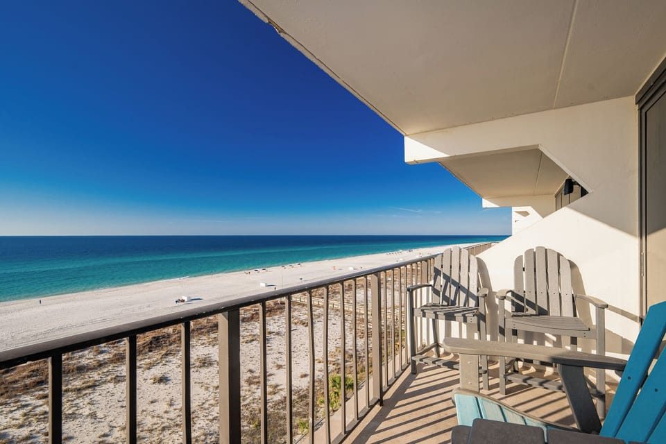 Enjoy breathtaking beachfront views from the balcony, featuring comfortable seating for relaxation and leisure