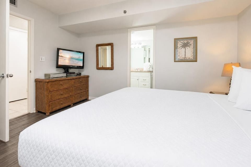 Crisp linens cover your king bed where you rest after a day of family fun by the shore
