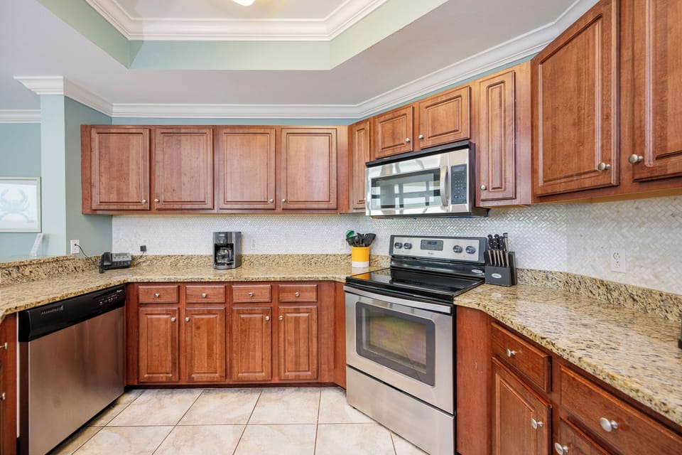Modern kitchen featuring stainless appliances, rich cabinetry, and elegant granite countertops for a stylish experience