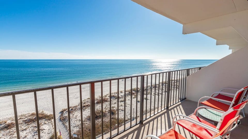 Enjoy breathtaking views from the balcony with comfortable seating overlooking the sandy beach and tranquil waters