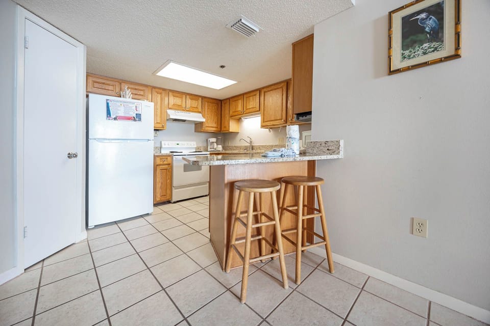 Cook and gather at the kitchen featuring wooden cabinetry and ample counter space for meal prep