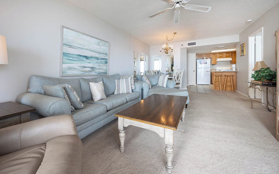Inviting living area, featuring comfortable seating, a wooden coffee table, and coastal decor