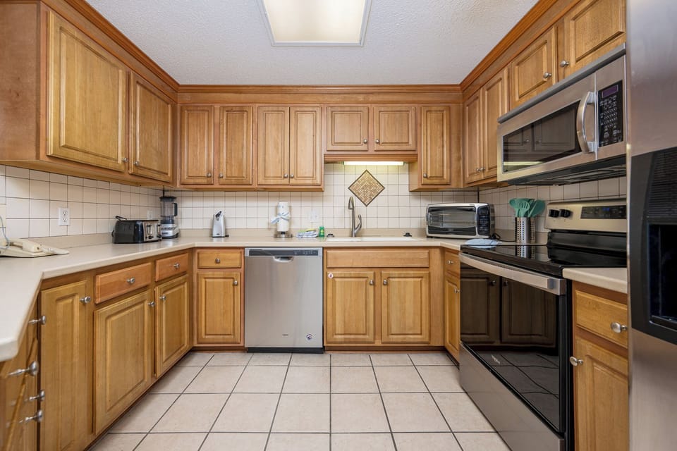 Cook and gather in this spacious kitchen featuring wooden cabinets, stainless appliances, and ample counter space