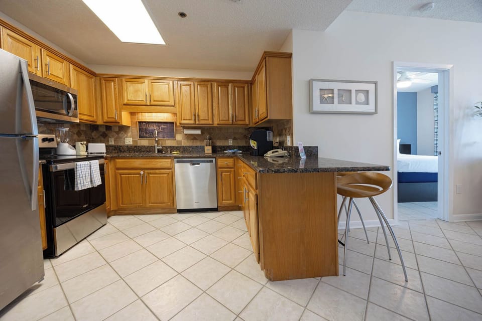 Cook and gather in the kitchen featuring wood cabinetry, granite counters, and a breakfast bar for casual dining