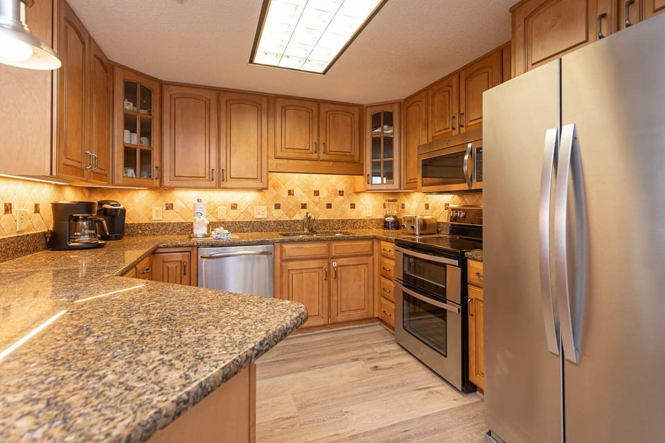 Cook and gather in this warm kitchen with granite counters, modern stainless appliances, and elegant cabinetry