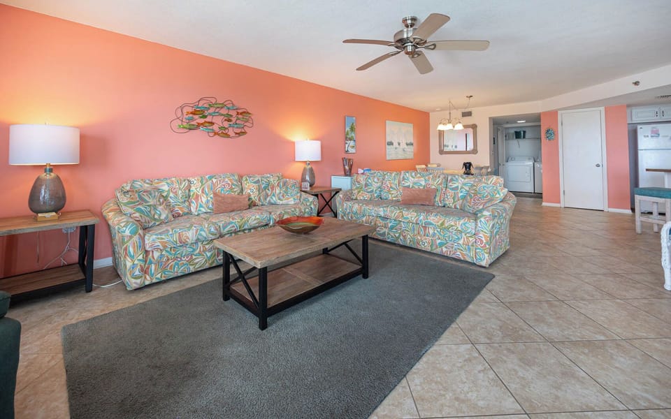 Tropical patterns complement the coral wall throughout, creating a cheerful living space with a cozy vibe