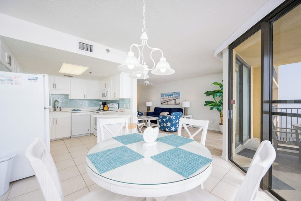 The living room welcomes you to sink into plush seating while enjoying soft lamplight and coastal wall art