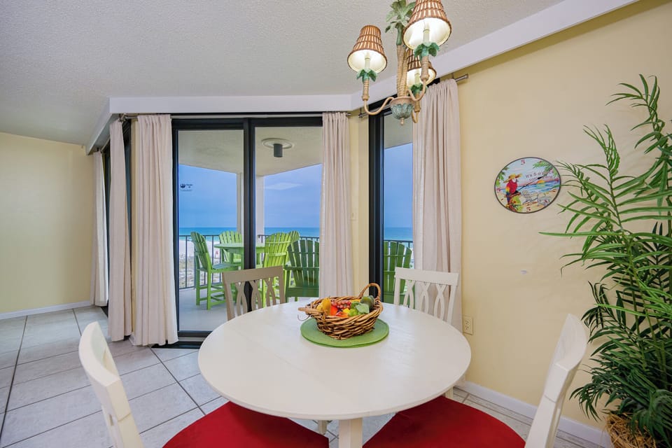 Tiled dining room invites you to gather around with fresh fruit while coastal breezes drift in through sliding doors