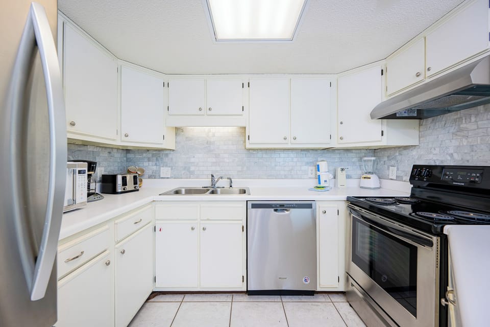 Sleek stainless appliances complement the kitchen where you prepare fresh gulf coast meals with ease