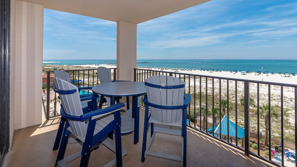 Enjoy your morning coffee at the balcony table with sweeping views of the beach and turquoise waters