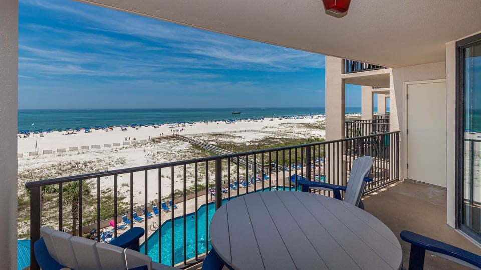 Relax on the balcony, enjoying views of the beach and the inviting pool below