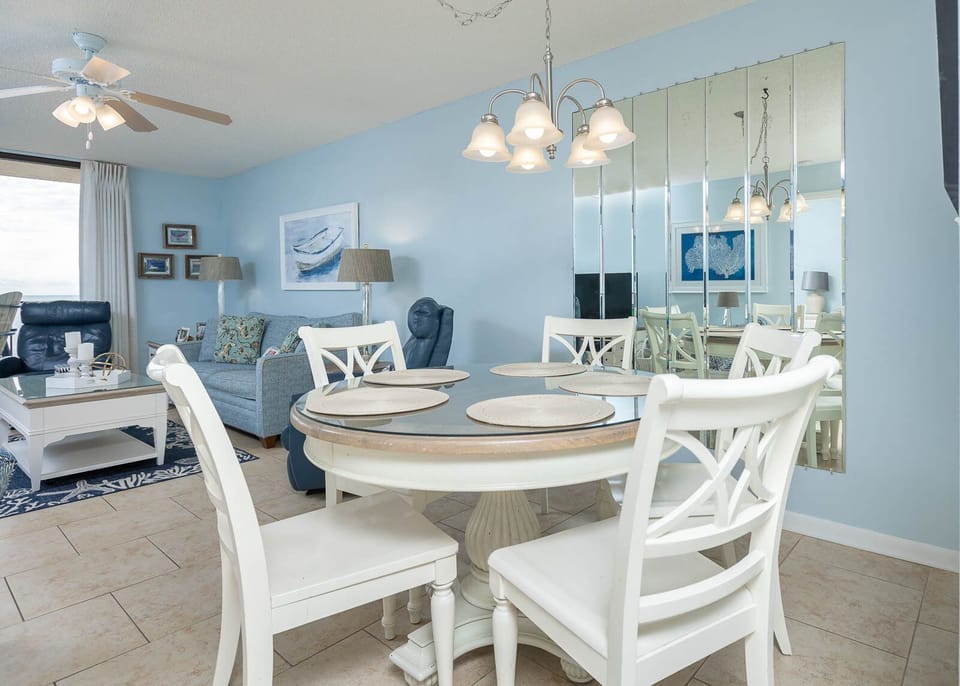 Dine comfortably at the round table, surrounded by coastal decor and inviting seating in a relaxing atmosphere