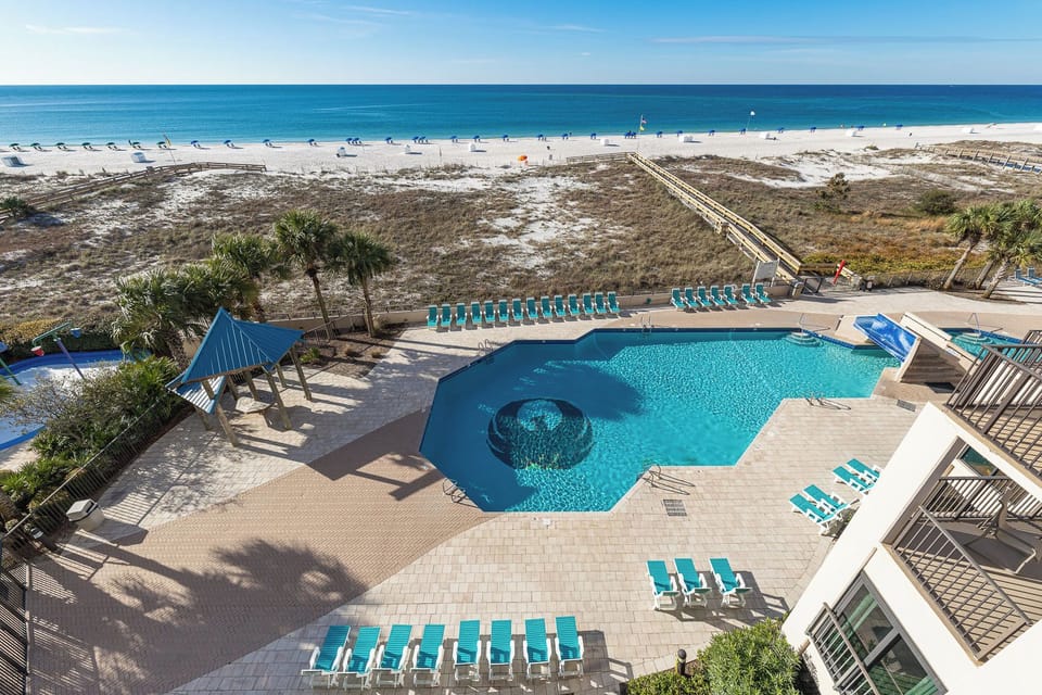 Relax by the poolside, soaking in the sun while enjoying views of the beach from your balcony