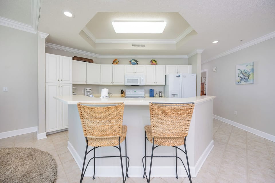 Savor your morning coffee at the cozy bar seating, surrounded by cheerful beach-themed decor