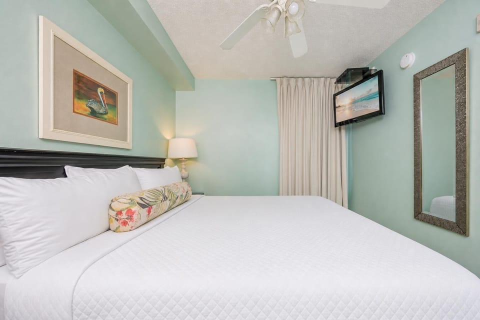 Fluffy pillows invite you to relax in the king suite for a calm movie night after a fun day at the beach
