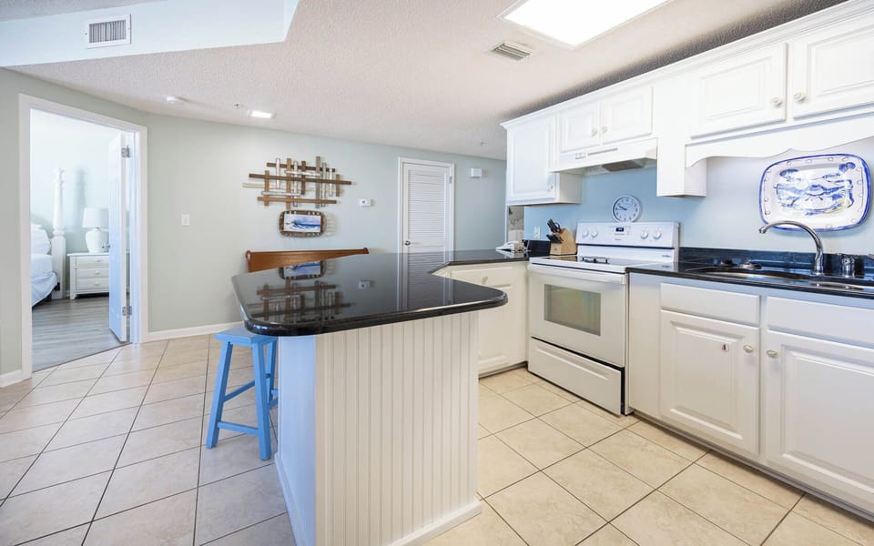 Cook meals in the stylish kitchen featuring a spacious counter, white appliances, and inviting decor for a delightful stay