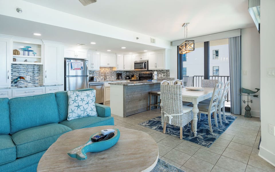 Relax in the inviting living space featuring a cozy sofa, dining area, and a stylish kitchen