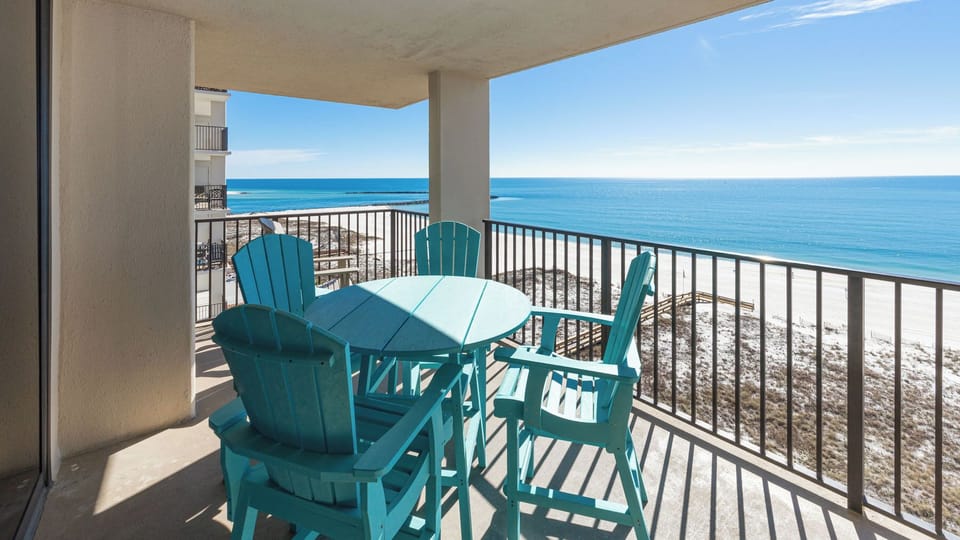 Relax at the turquoise table set on the balcony, enjoying expansive views of the tranquil waters and shoreline