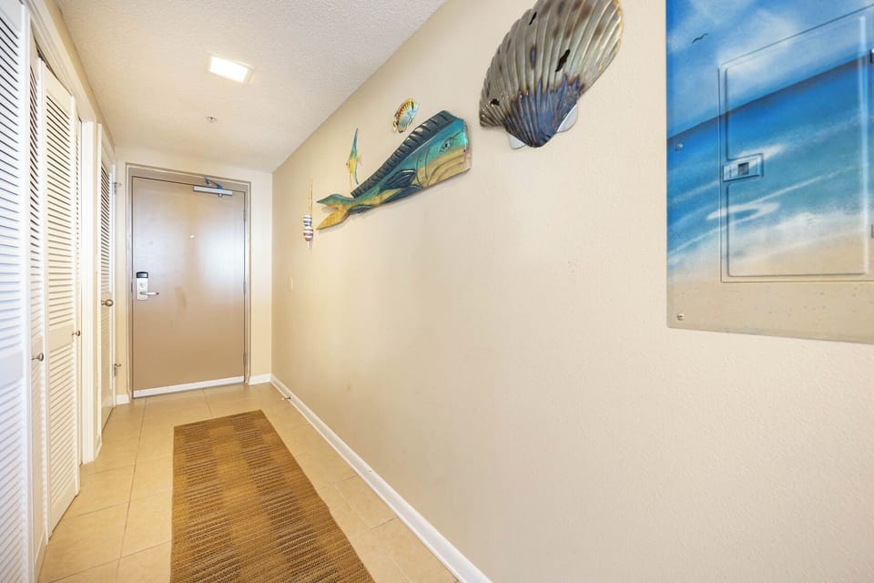 Step into a welcoming hallway adorned with coastal decor, leading you to your beachfront getaway
