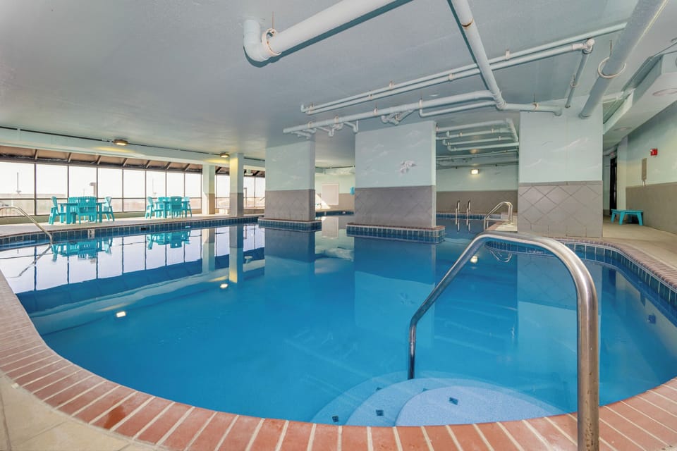 Relax in this indoor pool area with bright views and seating at Phoenix X, perfect for unwinding after a day at the beach