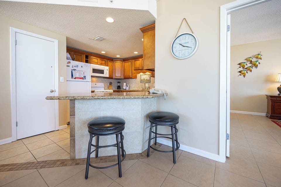 Gather around the bar stools at the kitchen counter, enjoying easy access to the kitchen and inviting decor
