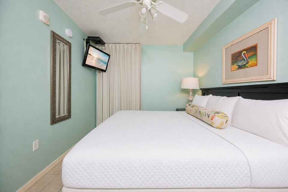 Fluffy pillows invite you to relax in the king suite for a calm movie night after a fun day at the beach