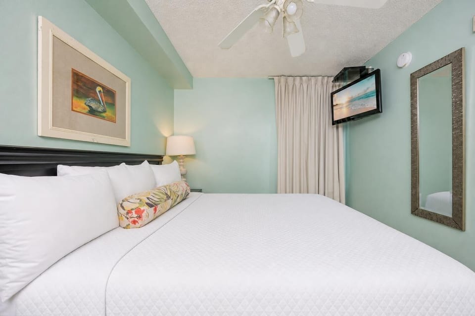 Fluffy pillows invite you to relax in the king suite for a calm movie night after a fun day at the beach
