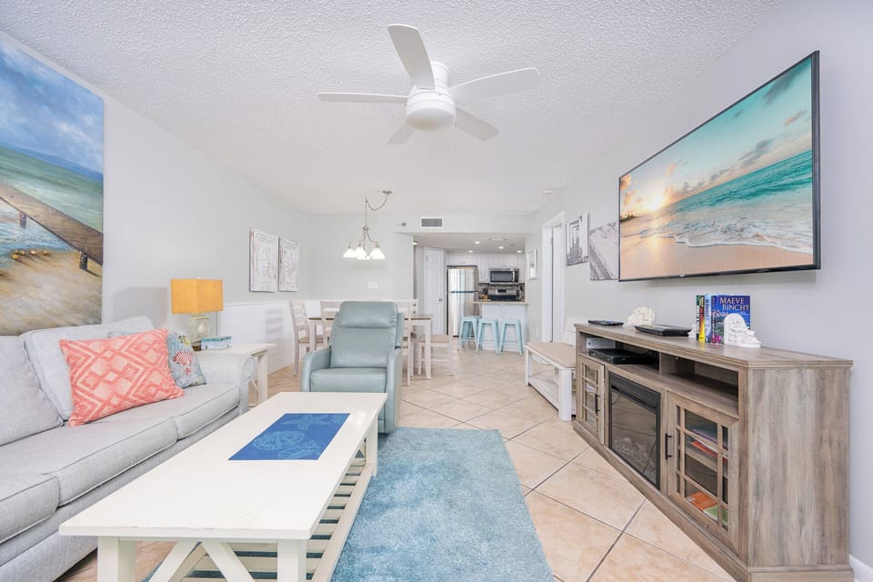 Unwind in the inviting living area, featuring a comfortable sofa with queen sleeper, vibrant decor, and a large TV