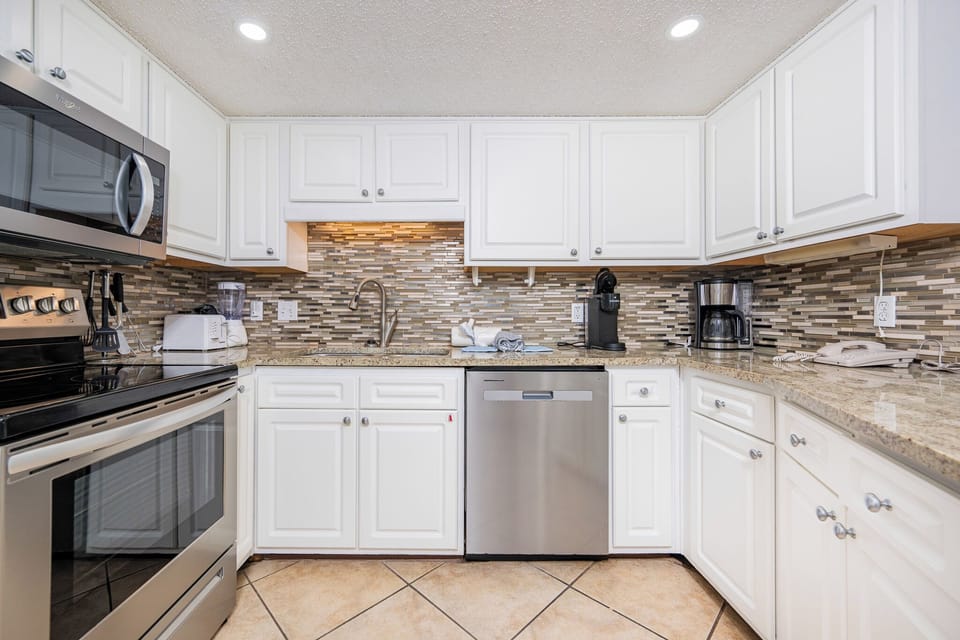 Prepare meals in the stylish kitchen featuring stainless appliances, elegant countertops, and a decorative backsplash