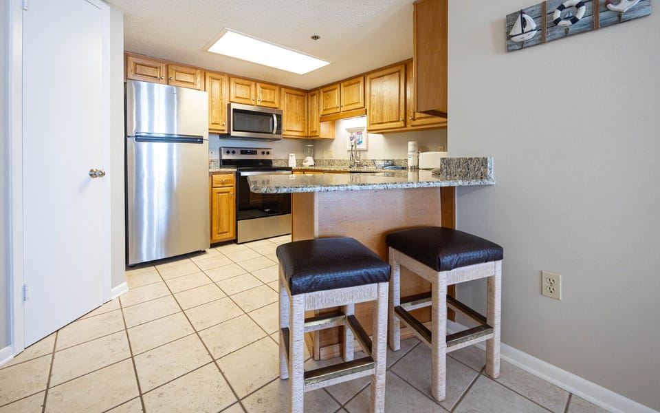 Prepare meals in this kitchen, featuring stainless appliances and granite countertops