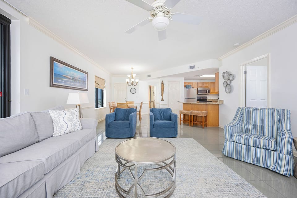 Relax in the inviting living area with comfortable seating and a view of the dining space and kitchen beyond