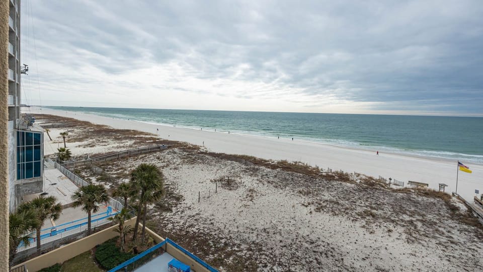 Gaze at the tranquil waters and beach from your seating area, perfect for relaxation and enjoying the view